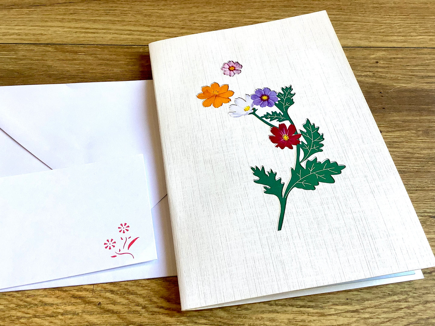 Dreidimensionale Klappkarte, aus der sich beim Öffnen ein leuchtend buntes Blumenbouquet entfaltet. Fairtrade aus Vietnam.