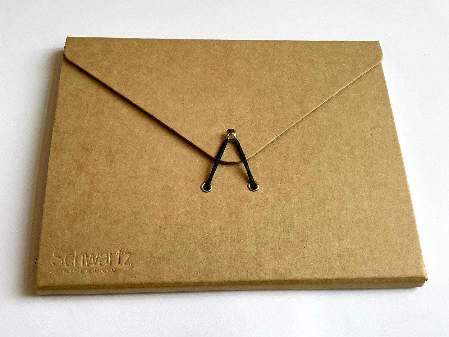 braune Sammelmappe in A5, die mit einem schmwarzen Gummiband über einem Metallhäkchen verschlossen wird, edles Design, kraftfarben