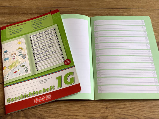 Aufgeschlagenes Geschichtenheft fürs erste Schuljahr, rechte Seite liniert, linke Seite blanko für Bilder. Brunnen