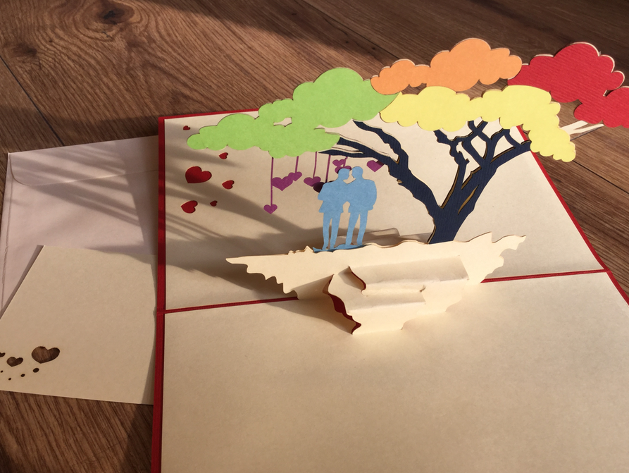 romantische Karte für eine Schwulenhochzeit-3D-Pop-Up-Karte zwei Männer unter einem regenbogenfarbenem Baum, von dem Herzen hängen