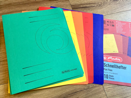 grüne, gelbe, orangene, rote und blaue Schnellhefter auf Pappe, je 2x, Linien auf dem cover