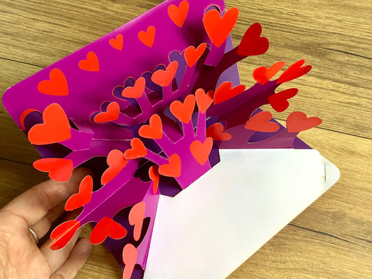 Pop-up-karte, aus der sich beim Aufklappen 27 rote Herzen strecken. 
Bei Polly Paper in Berlin-Mitte