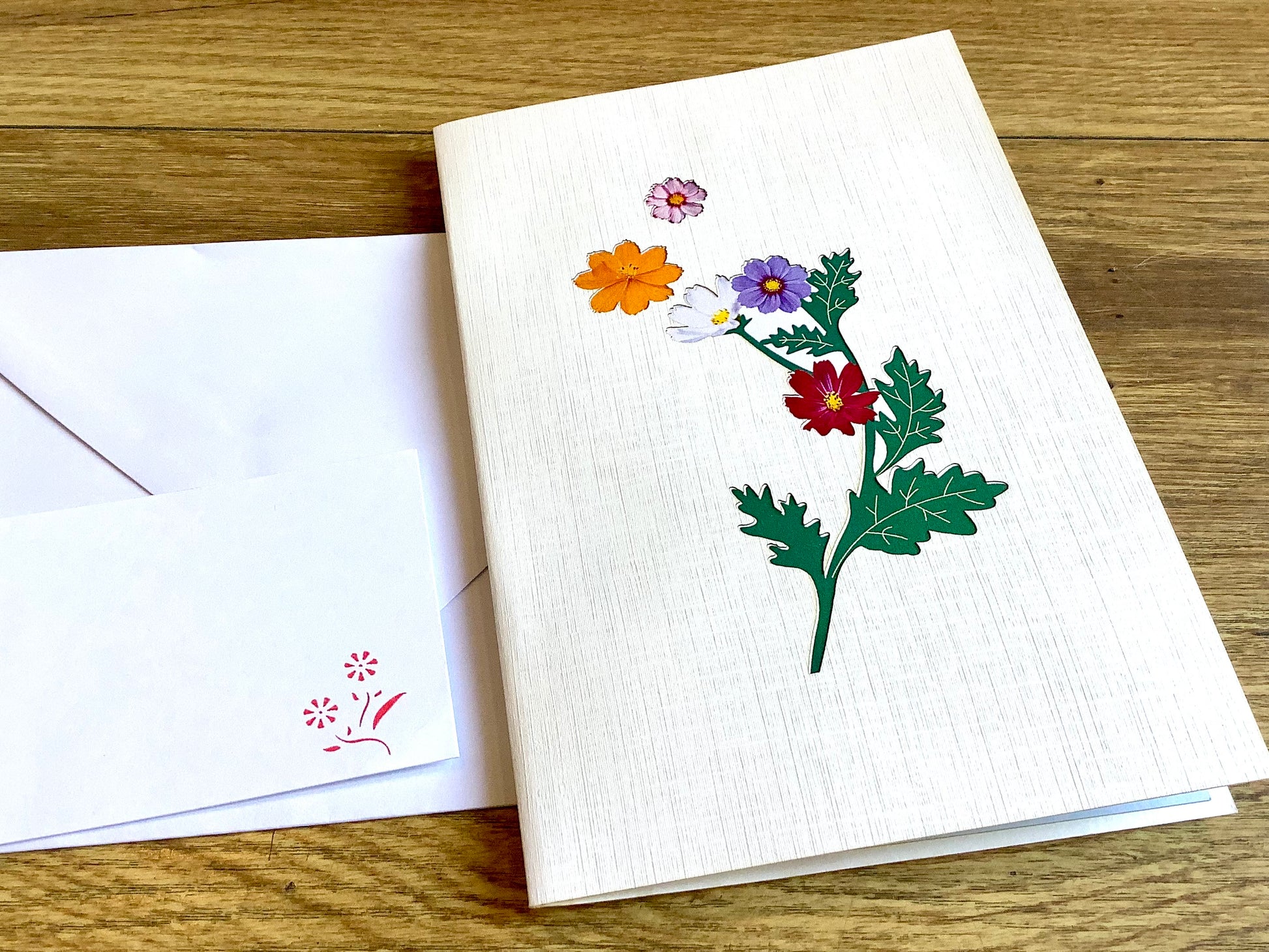 Dreidimensionale Klappkarte, aus der sich beim Öffnen ein leuchtend buntes Blumenbouquet entfaltet. Fairtrade aus Vietnam.