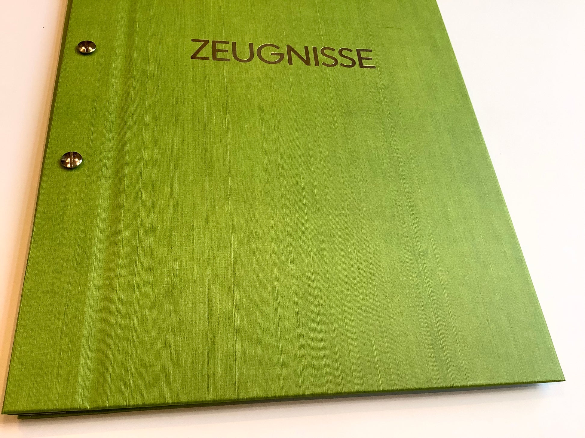 Grüne Zeugnismappe von Goldbuch mit Buchschrauben, mit deren Hilfe sich die Mappe erweitern lässt.