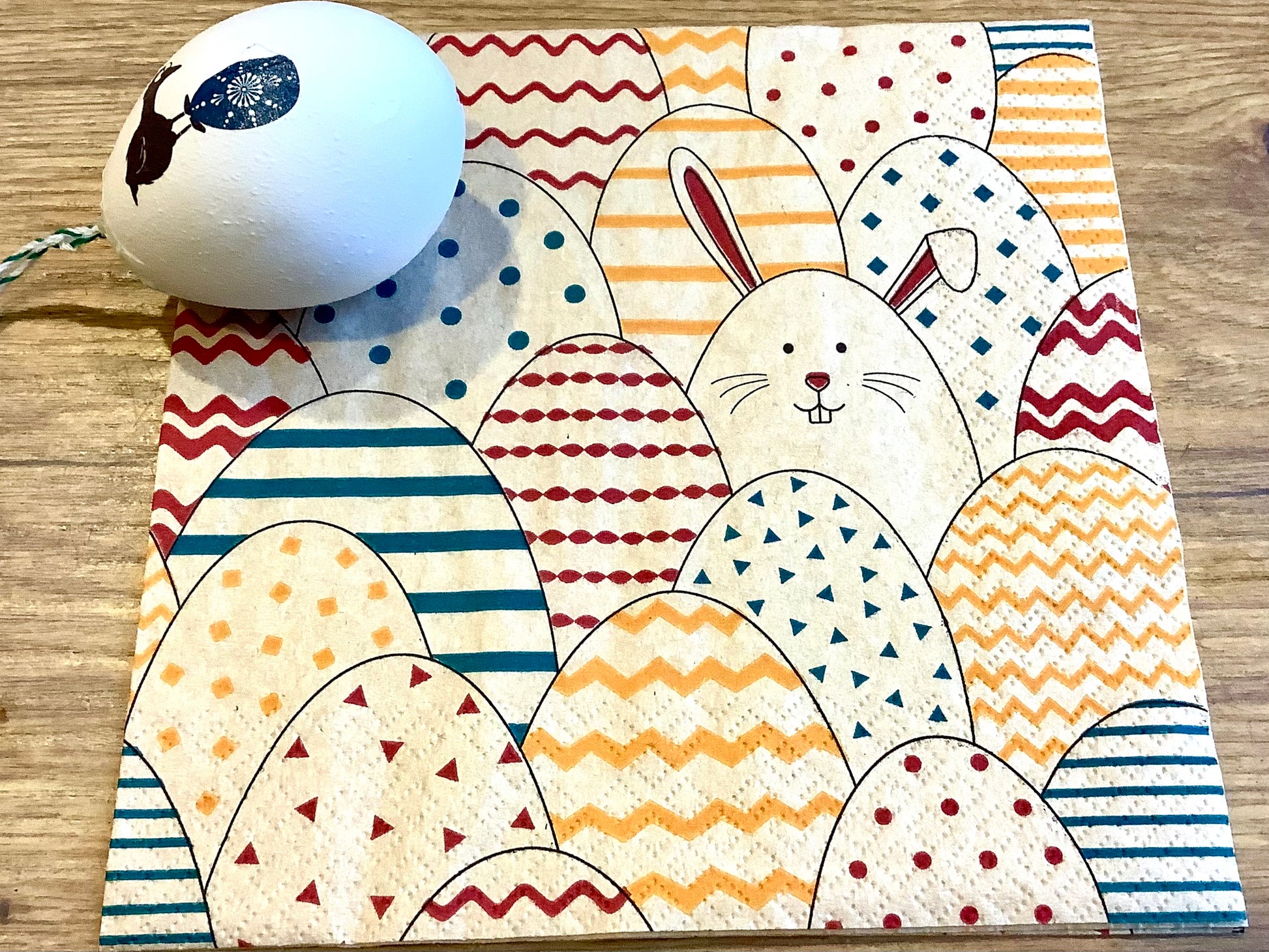 Österliche Papierservietten mit bunten Ostereiern und einem Häschen