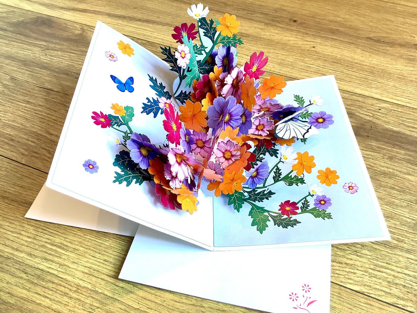 Dreidimensionale Klappkarte, aus der sich beim Öffnen ein leuchtend buntes Blumenbouquet entfaltet. Fairtrade aus Vietnam.