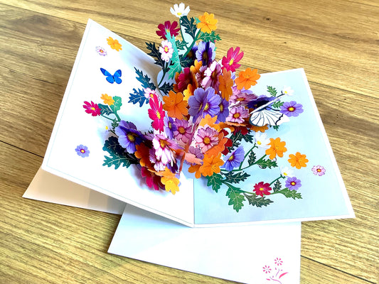 Dreidimensionale Klappkarte, aus der sich beim Öffnen ein leuchtend buntes Blumenbouquet entfaltet. Fairtrade aus Vietnam.