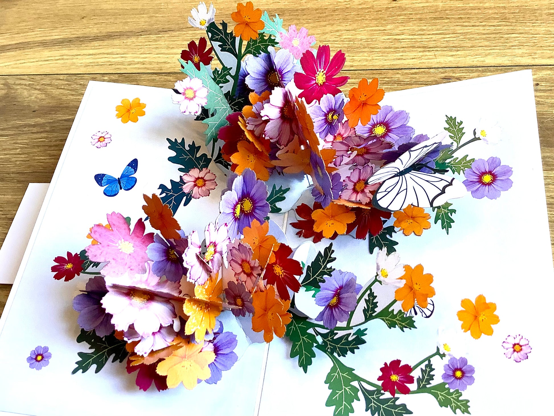 Dreidimensionale Klappkarte, aus der sich beim Öffnen ein leuchtend buntes Blumenbouquet entfaltet. Fairtrade aus Vietnam.