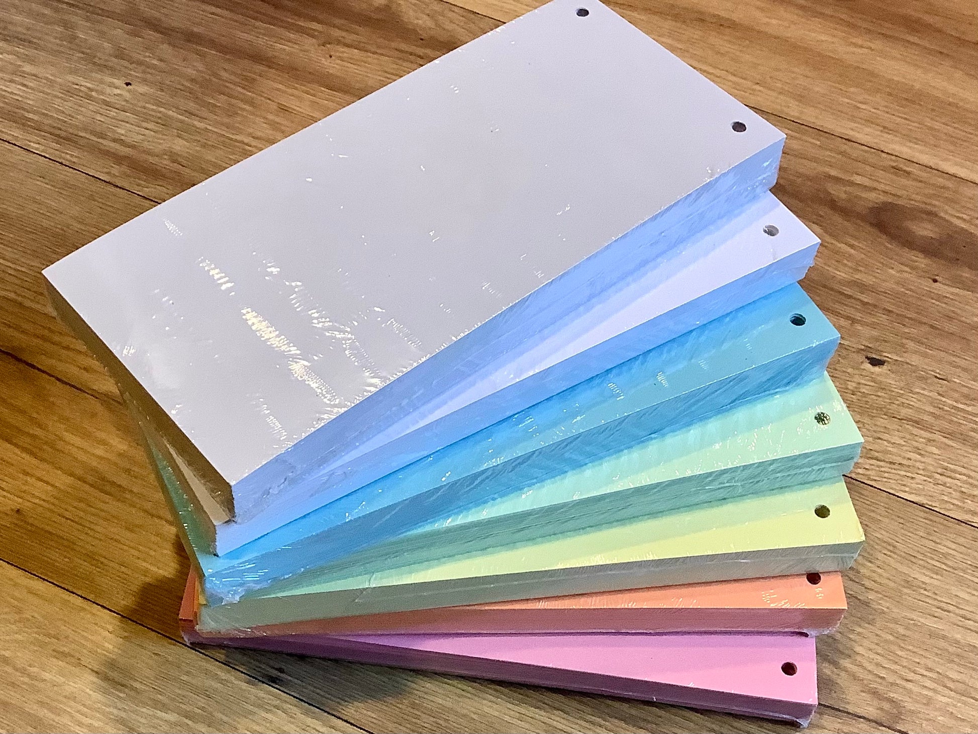 Trennstreifen aus Recyclingpapier in den Farben rosarot, orange, gelb, grün, blau, weiß und grau