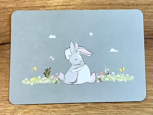 Postkarte: Zwei kleine Hasen umarmen sich auf einer Blumenwies