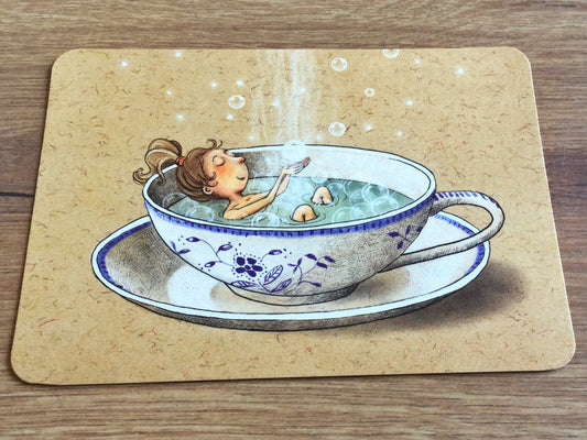 Die Postkarte zeigt eine blauweiß-geblümte Tasse mit dampfendem Tee, in dem ein Mädchen badet und mit Seifenblasen spielt. Gutrath-Verlag. 
Erhältlich bei Polly Paper - Umweltfreundliche Schreibwaren in Berlin Mitte