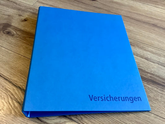 Blauer Ordner  mit der Aufschrift "Versicherungen"